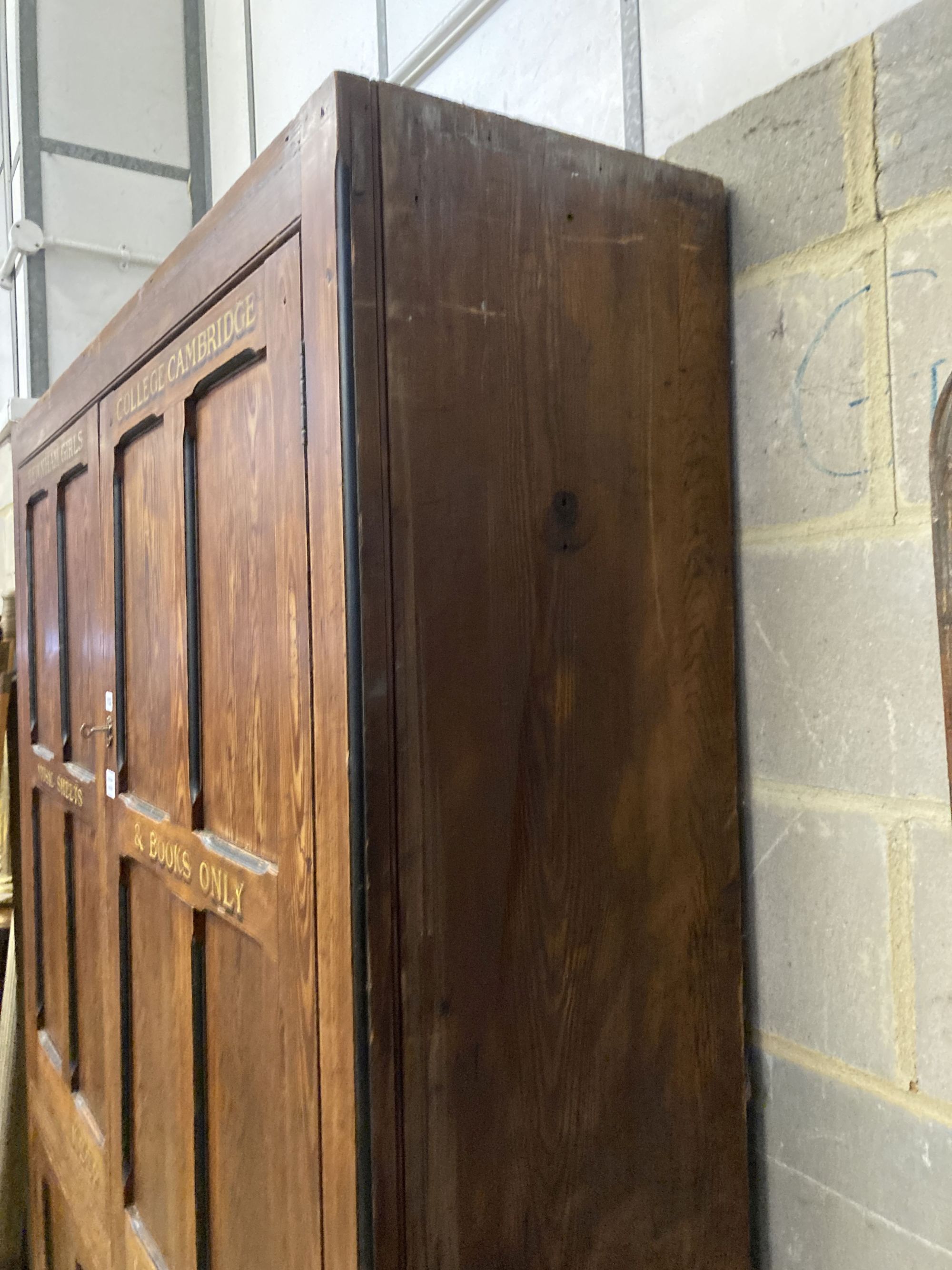 A Victorian panelled pitch pine four door cabinet, upper section marked in gilt, Newnham Girls College Cambridge music sheets and book